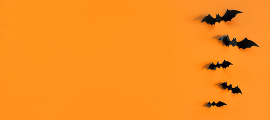 Halloween card with black bats on orange background. Banner for congratulations or invitation.