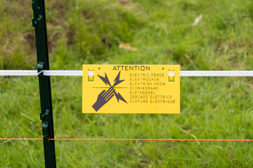 Electric fence warning sign in multiple languages