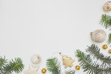Christmas corner border made of fir tree branches and golden decorations on white background