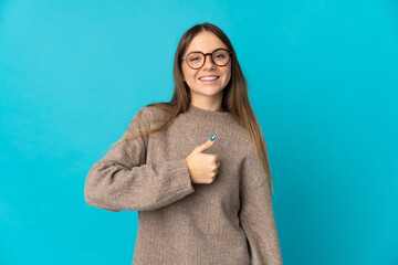 Young Lithuanian woman isolated on blue background giving a thumbs up gesture