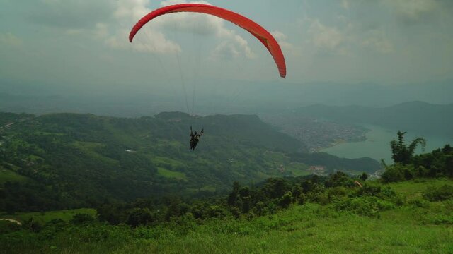 paraglider in the mountains over a lake