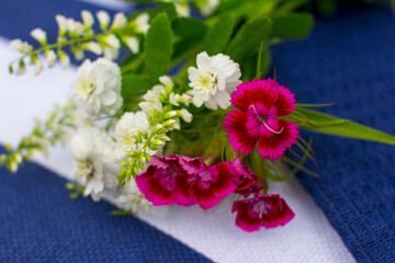 A bright multicolored bouquet of garden flowers on a striped blue background.