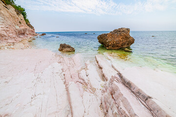 Pebbles beach colorful bay in Conero natural park dramatic coast headland rock cliff adriatic sea...