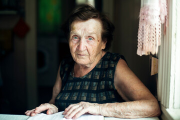 An old woman, a portrait in her house.