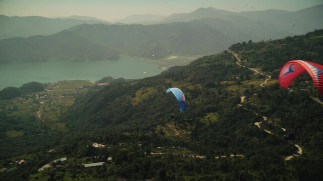 paragliding in the himalayan mountains over a lake