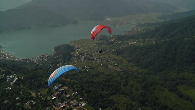 paragliding in the himalayan mountains over a lake