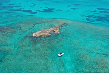 Fototapeta na wymiar Aerial view of boats anchored near coral rocks off North Bimini, Bahamas on sunny summer afternoon.