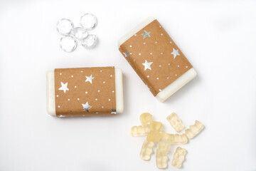 handmade craft soap in craft packaging on a white background with sweets and fake diamonds