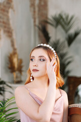 portrait of a young, beautiful woman with makeup made of mother-of-pearl pearls on her face and...