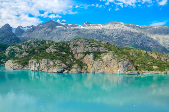 Alaska landscape mountains and water. Mountains reflection in the water. Remote location, unplugged. Wild beauty in nature. Untouched environment. Turquoise water color.