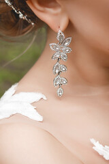 Element of decoration and decor at the wedding of the girl bride earring in the ear, close-up