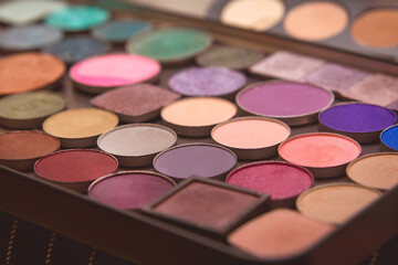 Obraz na płótnie Canvas Multi-colored eye and makeup palette shades, women's cosmetics close-up