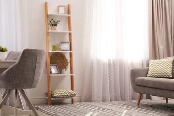 Stylish living room interior with wooden ladder near white wall