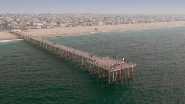 Aerial: Hermosa Beach Pier and tourists. Los Angeles, USA