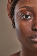Half face close up of young African-American woman looking at camera, authentic beauty