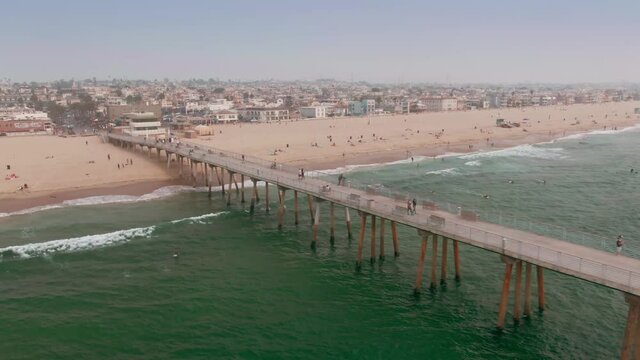 Aerial: Hermosa Beach Pier and tourists. Los Angeles, USA