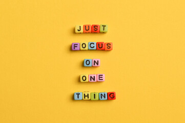 Alphabet letters with text JUST FOCUS ON ONE THING. Motivational quote.