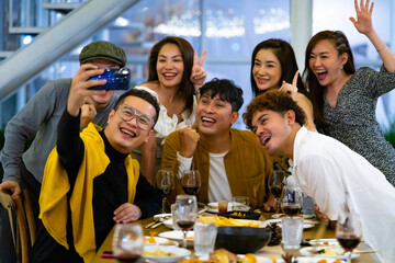 Group of Happy diversity Asian millennial people friends enjoy outdoor dinner party and using smartphone taking selfie together. Reunion friendship meeting celebration party and night life concept.