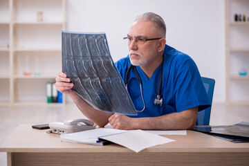 Old male doctor radiologist working in the clinic