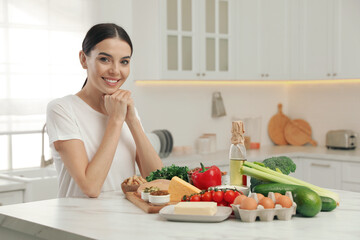 Happy woman with different products in kitchen. Keto diet