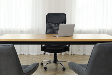 Director's office with large wooden table and comfortable armchairs. Interior design