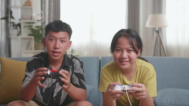 Asian Children With Joystick Game Playing Video Games At Home
