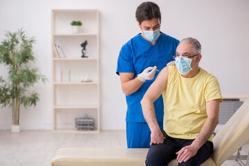 Old male patient visting young male doctor in vaccination concep