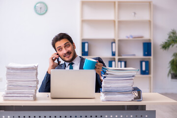 Young businessman employee and too much work in the office