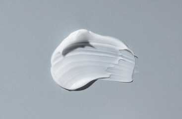 White cosmetic cream on gray background.