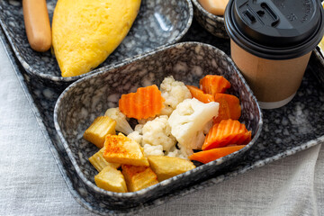 Breakfast set including croissant, vegetable, egg, ham, sausage and fresh fruit with coffee