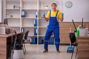 Young male contractor cleaning the office