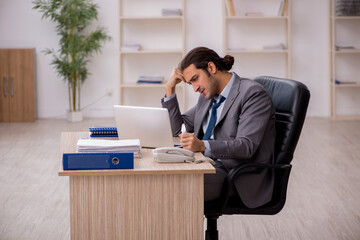 Young male sick employee working in the office