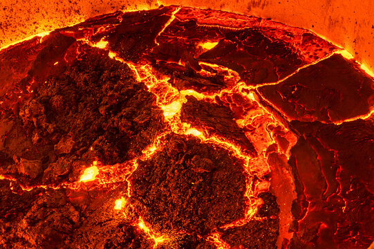 The surface of a hot liquid slag in a metallurgical ladle. Thick crust covered with trash net