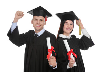 Happy students in academic dresses with diplomas on white background