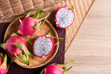 Dragon fruit or pitaya in a basket on woden background, Tropical fruit, Table top view