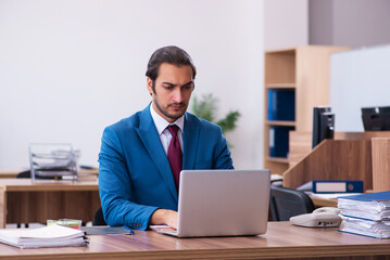 Young male employee working at workplace