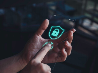 Smartphone security and privacy concept. Finger scanning on fingerprint scanner and blue shield with lock icon graphic on screen of very thin futuristic glass phone in hand on dark tone background.