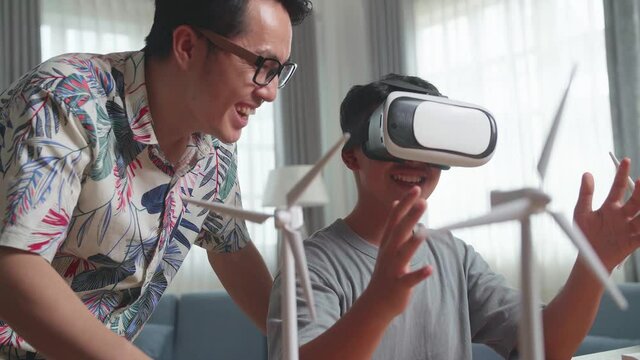 Asian Teacher Teaching Boy While Wearing Vr Glasses With Wind Turbine Model
