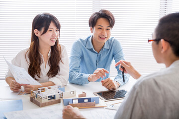 住宅模型を見ながら打ち合わせする施主と設計師