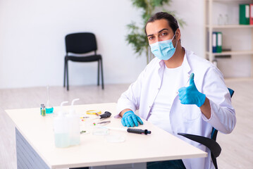 Young male chemist working in the lab during pandemic