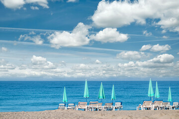 Obraz premium Morning sea, beach, empty sun beds for vacationers. Concept of travel, rest, relax.