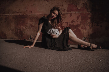 Curly girl in a black dress against the backdrop of the city