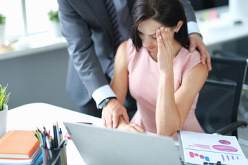 Businessman calming down young fatigue colleague at workplace