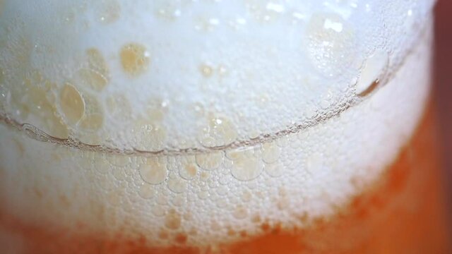 Detailed super slow motion footage of a beer. glass being filled up with lager beer. Foam builds up in a steady pace. Beer and beverage concept.