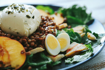 Healthy vegetable salad of fresh tomato, cucumber, onion, spinach,eggs, lettuce and sesame on plate.