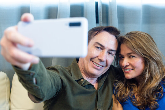 Smiling mature man and woman taking a selfie.