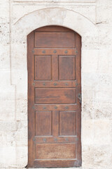 Ancient wooden door in old stone castle wall