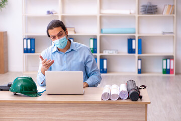 Young male architect working in the office during pandemic