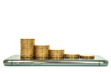 Business Money, Financial and Technology Concept. Closeup of stack of gold coins on mobile...