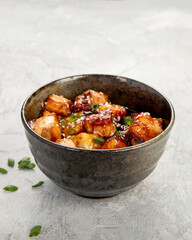 Traditional homemade fried tofu with sesame on light gray background.